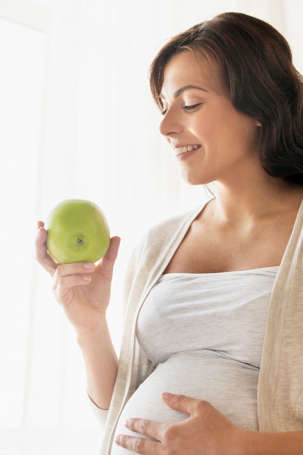 kobieta w ciąży jedząca jabłko