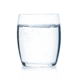 Glass of clear, sparkling water against a white background, representing a drink to prevent dehydration